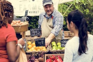 Photo of a Man Selling Produce at the Norwich Farmers Market.