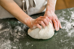 Photo of a Person Kneading Bread at King Arthur Flour in Vermont.